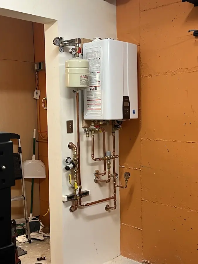 Plumbing technician inspecting water heater connections in Hazard